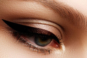 A close up of a woman's eye with black eyeliner.
